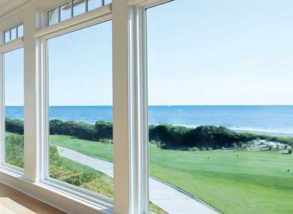 Large white framed Andersen windows overlooking the ocean