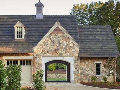 Front view of a rural, mid-class home with dark gray Ludowici tiles on its roof