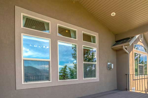 Front deck of a house with three windows on the wall